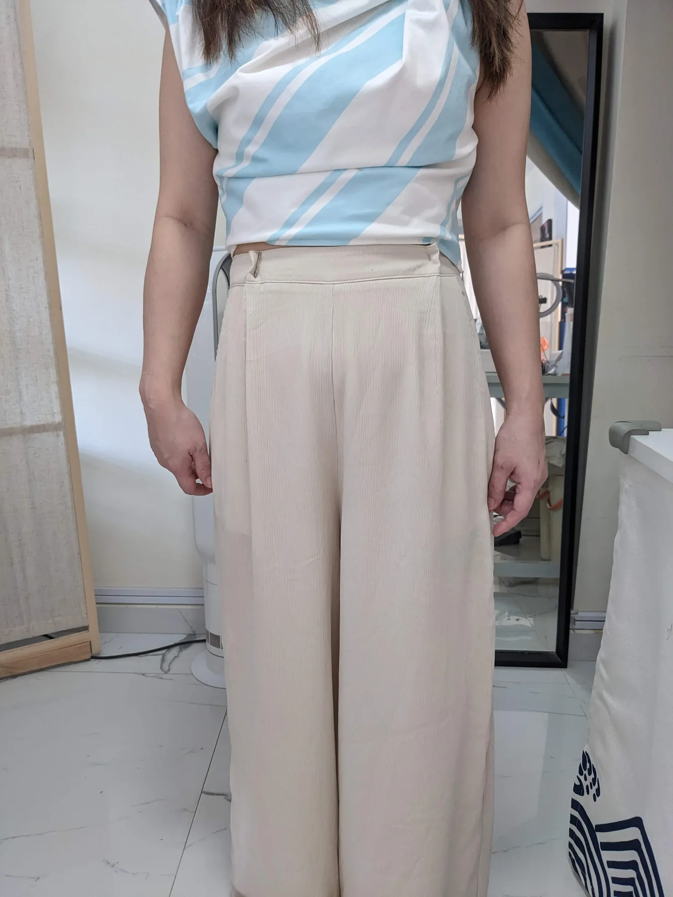 Client showcasing beige trousers after hemming and fit adjustment