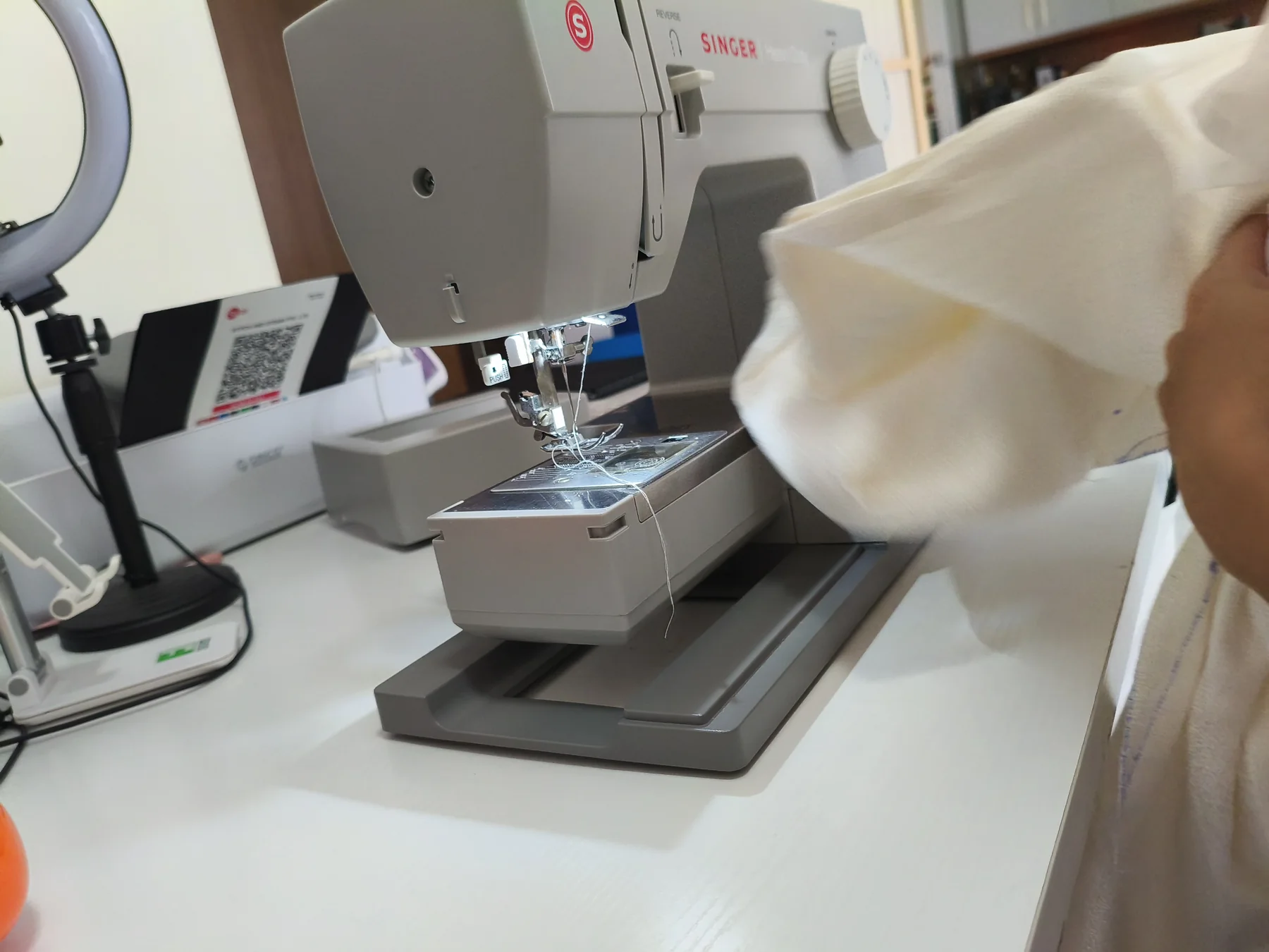 Tailor operating a sewing machine during garment alteration work