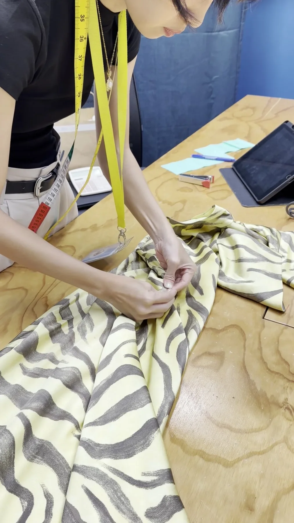 Tailor preparing patterned fabric for measurement and alteration